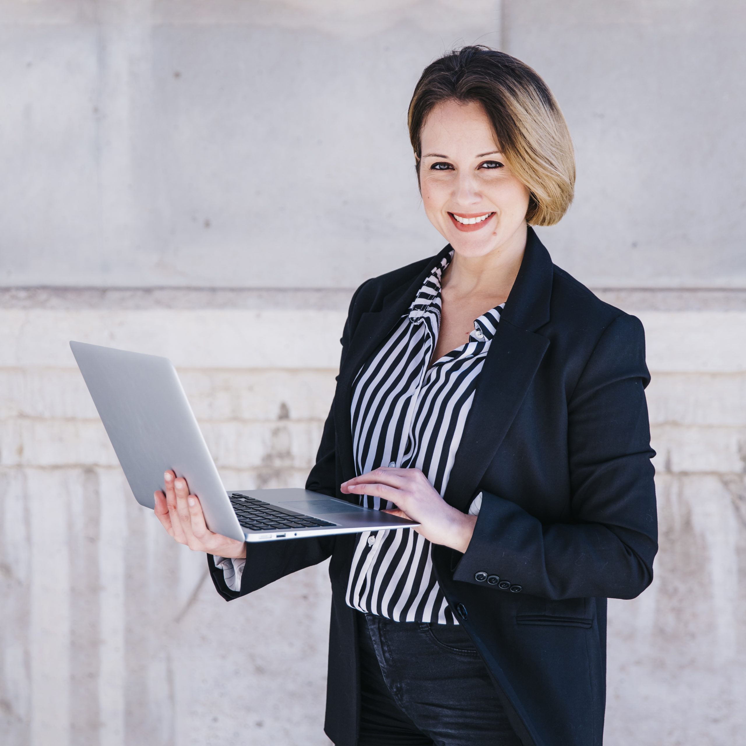 femme-affaires-navigation-ordinateur-portable-dans-rue support-informatique-pour-entreprise